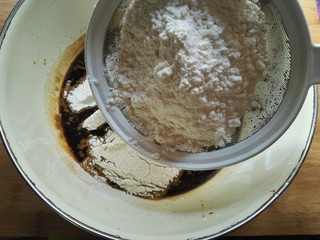 5、红糖开花发糕,把泡打粉加入面粉中一起过筛到红糖水中。