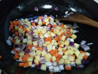 8、鸡肉咖喱面条,把洋葱丁,土豆丁,胡萝卜放鸡肉一起炒。