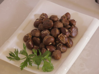 7、家庭秘制糖炒板栗,用筛子过滤掉板栗上的盐和糖，即可装盘。