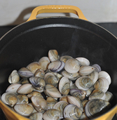 3、酒蒸蛤蜊,倒入沥干水的蛤蜊,转中大火翻炒几下。