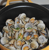 6、酒蒸蛤蜊,打开盖子让酒充分挥发,待蛤蜊全部张口后,加入一茶匙生抽翻炒一下。再放入一小块黄油,等黄油全部融化,关火撒少许香葱碎即可。