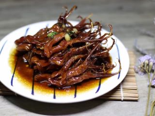 12、红烧鸭舌,最后把香葱汤汁浇在鸭舌上,美美的红烧鸭舌就可以上桌了。