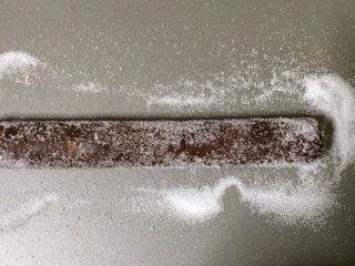 13、可可杏仁饼干,将烤箱温热至180°C 把砂糖放在蝙蝠上，滚动冷冻的面团，覆盖整个。