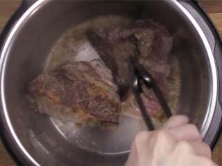 3、暖心的炖牛肉,开火热锅，加橄榄油 ，把牛肉的一面煎5分钟。