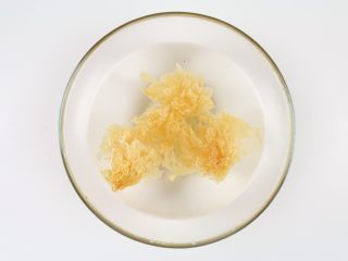 2、银耳木瓜糖水,银耳放入大碗里,加入适量的水泡20分钟左右。