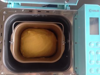 7、面包机版胡萝卜吐司,面团发酵时，可以在面包桶上盖一块湿布，再盖上面包机盖。这是发酵好的面团