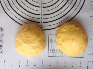 8、面包机版胡萝卜吐司,将面团取出排气，分成两等份，滚圆，盖上保鲜膜，静置15分钟