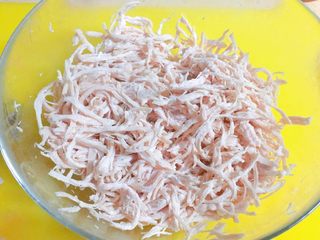 4、根本停不下来的★香辣烤鸡丝,时间到了之后，把肌肉捞出来，冷水泡一会儿，帮助其冷却。然后用手，把肌肉撕成丝，这个过程需要耐心，佳儿是大概撕了20分钟，也可以用俩个叉子，帮助你撕哦。不过我这个鸡肉太嫩了。叉子会扯断。我就手撕的。