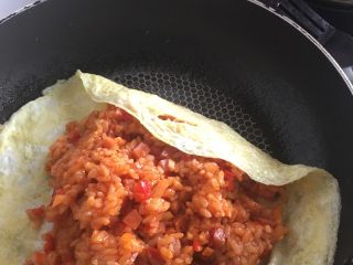 9、蛋包饭오뭐 라이스,加入炒饭,鸡蛋饼一边掀起来,锅里要有油,以便于把蛋包饭翻倒盘子里