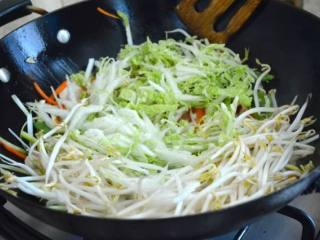 9、牛肉炒面,把所有的蔬菜都加到锅里。在高温下翻炒一分钟，然后在锅周围的圆周上加入一勺酒。