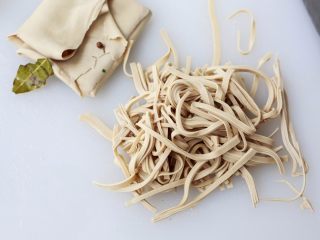 2、凉拌千张,浸泡入味的豆腐皮捞出来放凉，把豆腐皮从一边卷起来，这样方便把豆腐皮切成细条。