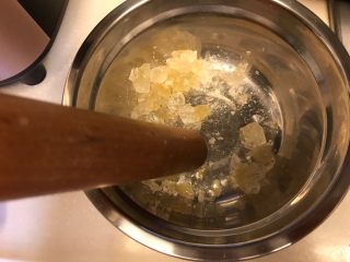 2、润肺神物《冰糖柠檬膏》【甜品篇】,烤完用工具处理成小块。因为经过烤箱的高温处理，冰糖很轻易被捣碎。