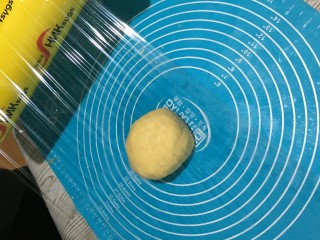 6、万圣节“捣鬼”糖霜饼干,捏好的面团,放在硅胶垫上,上面盖上保鲜膜。