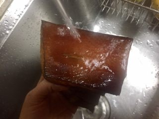 3、香蒜苗腊肉~年味美食,同时用热水洗腊肉用刀在腊肉表面刮出熏了的碳层，腊肉露出诱人焦黄的颜色
