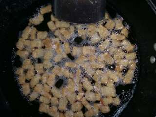 3、熬猪油,不断地搅拌避免糊底，直熬至肉渣有点微黄，关火。