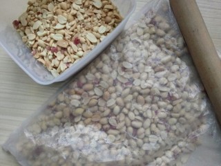 3、花生芝麻糖（家庭版）,拿擀面杖将花生压碎（不要太碎，小颗粒吃起来口感会更好）