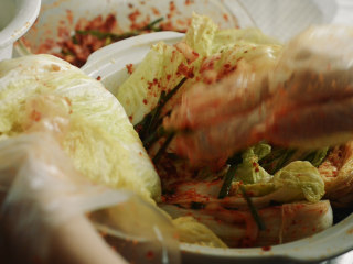 22、制作自家口味的韩式泡菜,把辣椒糊涂抹在每片叶片中间。