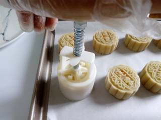 19、广式月饼~莲蓉蛋黄月饼,然后用模具压制。月饼全部压好后放入烤盘，或者直接在烤盘中压制，就不用在移动饼胚，不易引起变形。