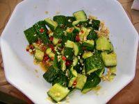 8、刀拍黄瓜,将辣椒段、花椒、葱花和热油淋在黄瓜段上即可