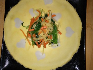 21、健康吃早餐――无油低脂手握三丝鸡蛋饼,将蛋皮平铺在盘子上,放上三丝,卷起来,并切掉两边。