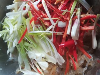 5、人人都爱吃凉拌海蜇皮,把蒜白丝和红辣椒丝倒进海蜇皮