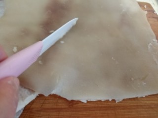 3、年菜_东北自制皮冻,焯好的猪皮用锋利的匕首刀刮猪毛。现在的猪皮一般都很干净,简单刮一下就行。