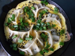 11、抱蛋煎饺,关火，撒上芝麻和香葱，锅内的余温会让蛋液全部凝固。