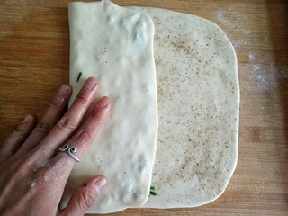 10、古早味麻酱红糖花卷&椒盐葱香花卷,将面饼左边三分之一折起，叠在葱绿上。