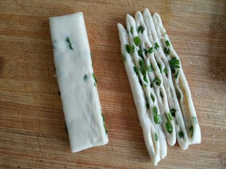 15、古早味麻酱红糖花卷&椒盐葱香花卷,再将每一份切4刀分成5条，有葱花的切面翻转朝上（如图所示）。