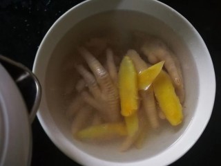 8、柠香泡椒凤爪,煮好的鸡爪放入大碗里，其他配料都不要留下生姜，倒入凉白开没过鸡爪浸泡一下。