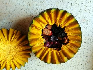 11、一品南瓜盅,用勺子将高压锅的食材放入小南瓜内，面上放一点红枣和龙眼干