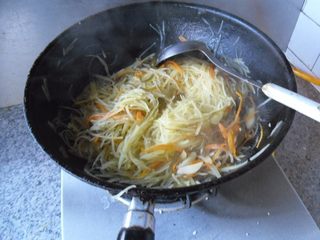 9、橄榄油小炒, 烹入少许水。翻炒至土豆丝熟透 