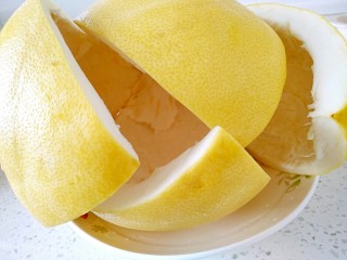 3、蜂蜜柚子茶,再用刀把果皮切开，取出果肉。