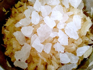 5、蜂蜜柚子茶,再把冰糖倒入果肉里搅拌均匀腌制出汁水