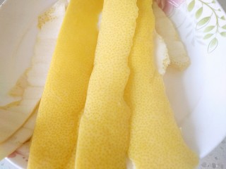 6、蜂蜜柚子茶,再用刀把果皮黄色部分削下来，尽量削薄些，白色的越多就会越苦