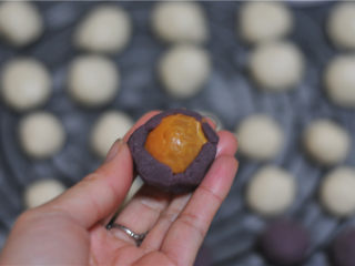 8、蛋黄酥,豆沙馅稍微按扁，将咸蛋黄放在中间，包裹起来，搓圆