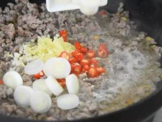 2、完美！比老干妈还要好吃的——牛肉酱,.转小火，倒入花生碎、姜蒜末、小米椒、圆葱，翻炒均匀