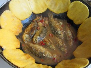 10、黄金小鱼锅贴,把玉米面糊在手上拍成扁扁的小饼子，然后左手拿着，右手粘一下清水再把饼子拿起贴在锅边四周，这样贴的时候饼子不会粘手