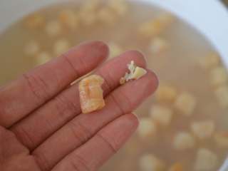 5、干贝玉米萝卜汤,去除干贝表面的杂质。