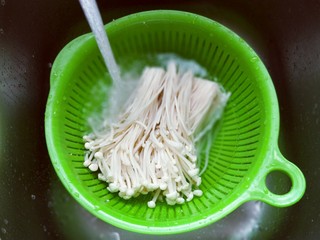 2、新年必备的双味儿蟹肉蒸金针菇,首先将金针菇去根。(切掉即可)