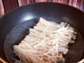 3、新年必备的双味儿蟹肉蒸金针菇,冲洗干净后将金针菇焯水，尽量不要把金针菇弄乱，保持整齐。(也可以不焯水，根据个人习惯)
