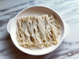 4、新年必备的双味儿蟹肉蒸金针菇,焯水的金针菇捞出摆盘。