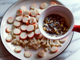 11、新年必备的双味儿蟹肉蒸金针菇,再将拌均匀的调味料淋再蟹肉棒金针菇上面即可。