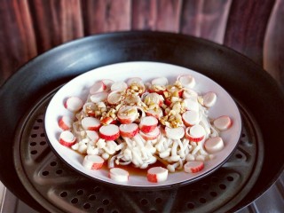 12、新年必备的双味儿蟹肉蒸金针菇,锅中加水烧开后将盘子放在蒸屉上，隔水蒸8分钟即可。