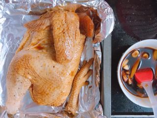 14、家庭烤鸡(烤箱版),取一个烤盘铺上锡纸,把鸡取出来放进去,将保鲜袋里的酱汁倒入碗中