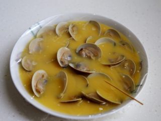 8、蛤蜊蒸水蛋,将煮开口的蛤蜊一个个地摆在盘中，蒙上微波炉专用保鲜膜，用牙签扎些小洞。注这样做蒸出的蛋就不会有小孔。