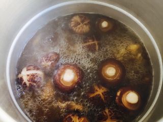 7、小鸡炖蘑菇#有个故事#,加入姜块和当归，加一勺酱油、料酒可多放点然后加足够的热水。热水莫过鸡肉的1/3即可