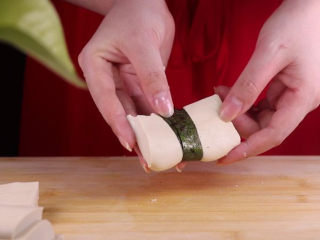 9、豆腐换种新吃法，招待客人倍有面子！,取一根海苔条，将豆腐拦腰绑带。（在封口处蘸点水，将海苔蘸连在一起这样海苔就不会散开了哦）