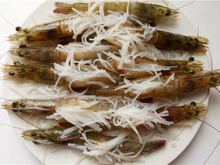10、粉丝蒜蓉蒸大虾,虾背中铺上粉丝末、蒜蓉。