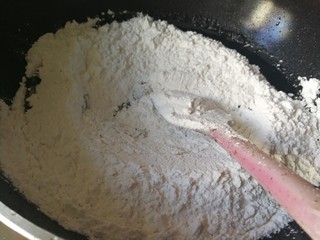 7、药膳美食之一一鸡屎藤糍粑,筛入糯米粉，一边煮一边搅拌均匀成光滑粉团。